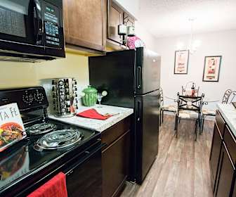 kitchen featuring refrigerator, electric range oven, microwave, stone countertops, dark brown cabinetry, pendant lighting, and light parquet floors, Park 88