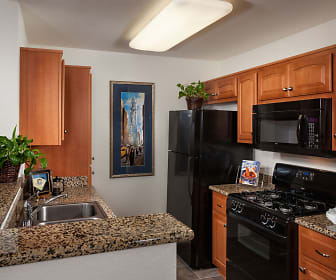 kitchen with gas range oven, refrigerator, microwave, dark flooring, dark granite-like countertops, and brown cabinets, Evergreen Park
