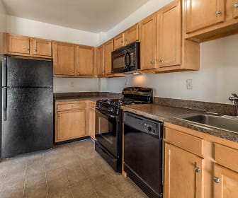 kitchen featuring gas range oven, dishwasher, microwave, refrigerator, dark granite-like countertops, light tile floors, and brown cabinets, Walden Park