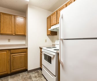 kitchen featuring ventilation hood, refrigerator, electric range oven, light countertops, light tile floors, and brown cabinets, Riverpark Apartments