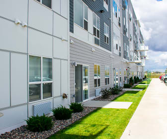 view of building exterior featuring an expansive lawn, Flats on 21