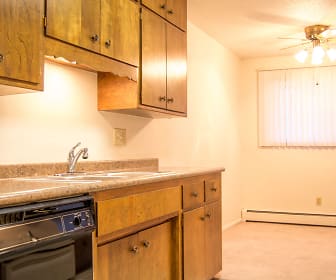 kitchen with carpet, a ceiling fan, baseboard radiator, dishwasher, light floors, brown cabinets, and light countertops, University Square