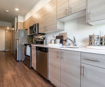 kitchen with refrigerator, microwave, stainless steel dishwasher, range oven, light parquet floors, light brown cabinets, and light countertops, Ethos