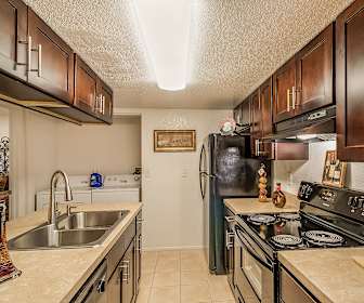 kitchen with extractor fan, dishwasher, electric range oven, washer / dryer, refrigerator, dark brown cabinetry, light granite-like countertops, and light tile floors, Melrose On The Bay