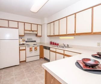 kitchen with refrigerator, dishwasher, electric range oven, fume extractor, light tile floors, light brown cabinets, and light countertops, River Park Tower Apartment Homes