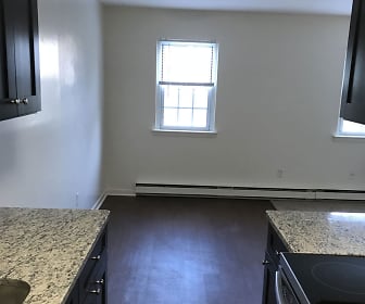 kitchen with natural light, baseboard radiator, dark hardwood flooring, dark granite-like countertops, and dark brown cabinets, Briarwood Commons