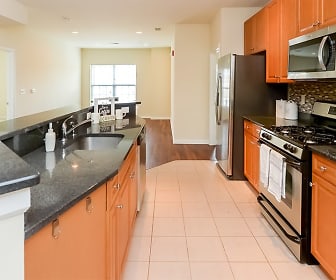 kitchen with natural light, stainless steel microwave, refrigerator, dishwasher, gas range oven, dark countertops, light tile floors, and brown cabinets, Cranford Crossing Apartment Homes