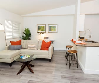 living room featuring hardwood floors, natural light, lofted ceiling, a breakfast bar area, and refrigerator, The Harbor