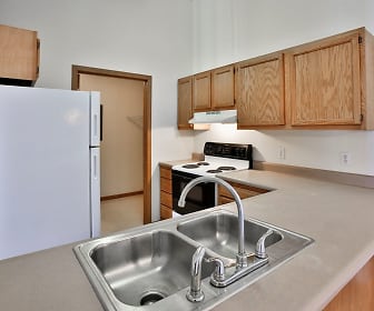 kitchen featuring refrigerator, electric range oven, extractor fan, light flooring, and brown cabinetry, Willow Crossing