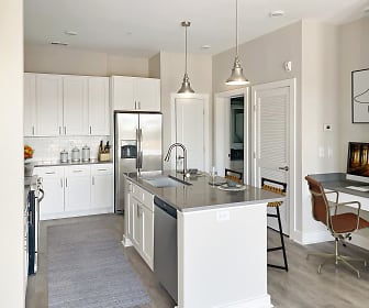 kitchen with TV, stainless steel refrigerator, range oven, dishwasher, white cabinetry, light flooring, a kitchen island with sink, and pendant lighting, Ansley Park
