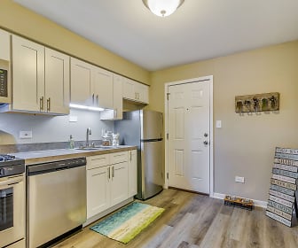 kitchen featuring stainless steel appliances, gas range oven, baseboard radiator, light countertops, light hardwood floors, and white cabinetry, Courtyards on the Park