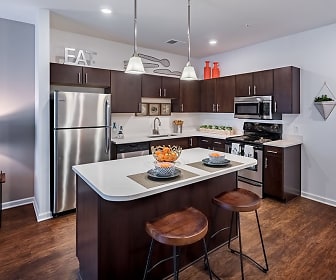 kitchen featuring a breakfast bar area, electric range oven, stainless steel appliances, dark brown cabinets, dark parquet floors, light countertops, and pendant lighting, The Kane Apartment Homes