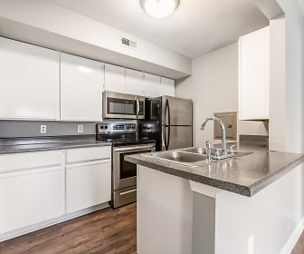 kitchen with stainless steel microwave, refrigerator, electric range oven, white cabinets, dark parquet floors, dark stone countertops, and a center island with sink, Pheasant Run