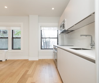 kitchen featuring a wealth of natural light, oven, microwave, light countertops, white cabinetry, and light hardwood flooring, 123 Highland Avenue