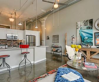 garage with a high ceiling, a ceiling fan, a kitchen bar, and stainless steel appliances, The Lofts At Mockingbird Station