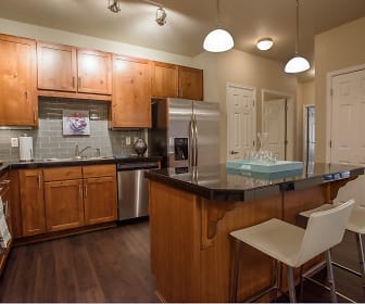 kitchen featuring a breakfast bar area, stainless steel appliances, range oven, dark countertops, dark parquet floors, pendant lighting, and brown cabinets, Whisper Sky