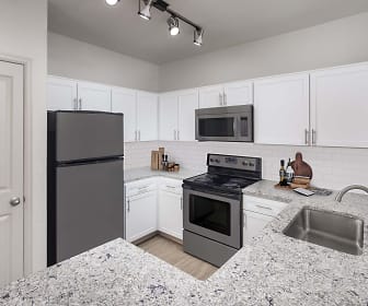 kitchen with refrigerator, electric range oven, stainless steel microwave, white cabinetry, light parquet floors, and light granite-like countertops, Camden Interlocken