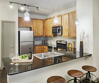 kitchen featuring a kitchen bar, stainless steel appliances, range oven, dark parquet floors, pendant lighting, and brown cabinets, Camden Design District