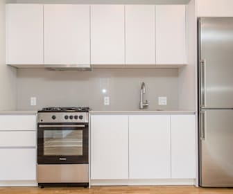 kitchen with ventilation hood, gas range oven, refrigerator, white cabinets, light countertops, and light hardwood floors, 136 Highland Avenue
