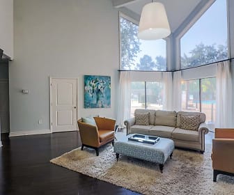 hardwood floored living room featuring generous sunlight, a high ceiling, and TV, The Park At Moss Creek