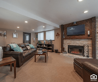 carpeted living room with a fireplace and TV, Oswego Cove