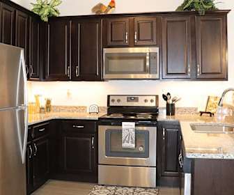 kitchen featuring stainless steel appliances, electric range oven, granite-like countertops, light hardwood flooring, and dark brown cabinets, Lexington Village