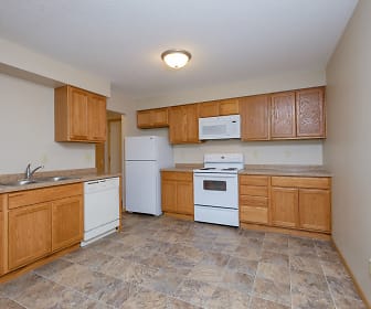 kitchen with refrigerator, electric range oven, dishwasher, microwave, light countertops, light tile floors, and brown cabinetry, University Square