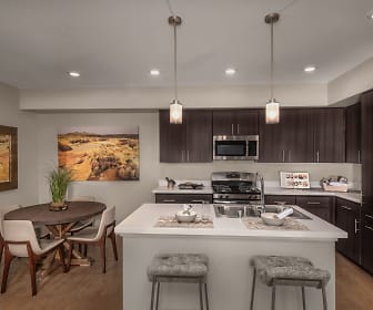 kitchen featuring stainless steel appliances, light hardwood flooring, light countertops, pendant lighting, and dark brown cabinets, Latitude 39