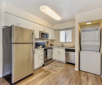 kitchen with natural light, washer / dryer, electric range oven, stainless steel appliances, white cabinets, light countertops, and light parquet floors, Silverstone