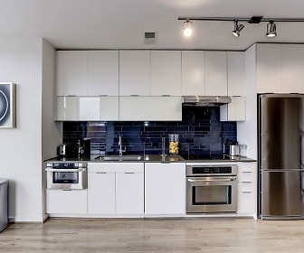 kitchen with range hood, electric cooktop, refrigerator, stainless steel double oven, white cabinets, dark countertops, and light parquet floors, The Shay