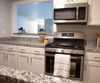 kitchen with gas range oven, stainless steel microwave, white cabinetry, and light granite-like countertops, Capella Apartments
