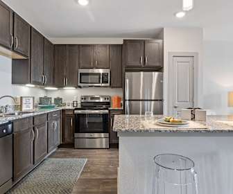 kitchen featuring stainless steel appliances, range oven, granite-like countertops, dark brown cabinetry, and dark floors, Oaks On Marketplace