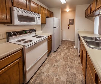 kitchen with refrigerator, electric range oven, stainless steel microwave, light tile floors, light countertops, and brown cabinetry, Bexley Village