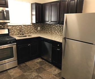 kitchen with stainless steel appliances, gas range oven, dark flooring, light granite-like countertops, and dark brown cabinets, Burnt Mill Apartment Homes