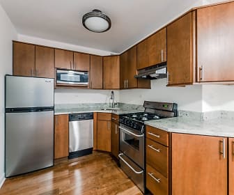 kitchen with stainless steel appliances, gas range oven, fume extractor, light hardwood floors, light stone countertops, and dark brown cabinets, 800 Hinman