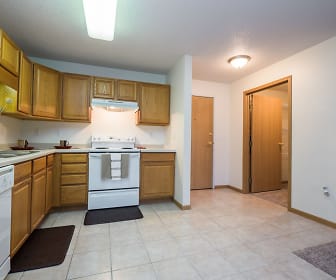 kitchen featuring dishwasher, electric range oven, fume extractor, light tile floors, light countertops, and brown cabinetry, Stonebridge Apartments