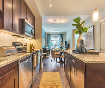 kitchen featuring a kitchen island, natural light, TV, electric range oven, stainless steel appliances, dark brown cabinetry, dark granite-like countertops, pendant lighting, and light parquet floors, Preston Hollow Village Apartments