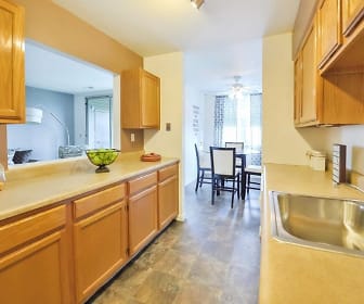 kitchen featuring a ceiling fan, light tile floors, brown cabinets, and light countertops, Summit Pointe Apartment Homes
