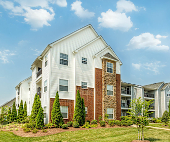 view of building exterior with a lawn, Crowne Village At Swift Creek