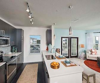 kitchen with stainless steel appliances, electric range oven, dark flooring, pendant lighting, dark brown cabinetry, and light countertops, Solaris Key