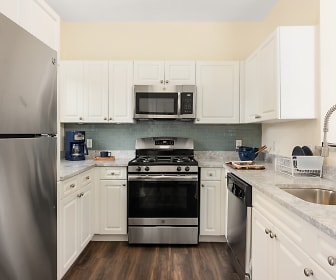 kitchen featuring stainless steel appliances, gas range oven, dark hardwood flooring, white cabinetry, and light granite-like countertops, Residences at Stevens Pond
