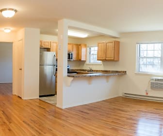 kitchen featuring natural light, baseboard radiator, stainless steel refrigerator, light hardwood floors, and brown cabinetry, Valley Apartments