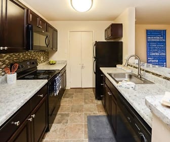 kitchen with refrigerator, dishwasher, electric range oven, microwave, dark tile flooring, dark brown cabinetry, and light granite-like countertops, The Greens at Westgate Apartment Homes