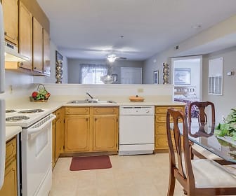 kitchen with electric range oven, refrigerator, dishwasher, fume extractor, light tile floors, brown cabinets, and light countertops, Woodbrook Apartments