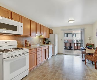 kitchen with gas range oven, refrigerator, dishwasher, microwave, light countertops, light tile floors, and brown cabinetry, Camelot Arms & North Hills