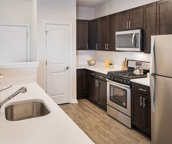 kitchen with stainless steel appliances, gas range oven, dark brown cabinetry, light countertops, and light hardwood floors, Summit Court