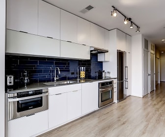 kitchen with electric cooktop, refrigerator, stainless steel double oven, exhaust hood, light flooring, dark countertops, and white cabinets, The Shay
