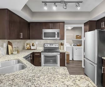 kitchen with hardwood floors, washer / dryer, electric range oven, stainless steel appliances, light granite-like countertops, and dark brown cabinets, Camden Grandview