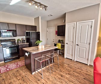kitchen featuring a breakfast bar, refrigerator, electric range oven, microwave, dark brown cabinetry, light parquet floors, and light countertops, Terra Vida