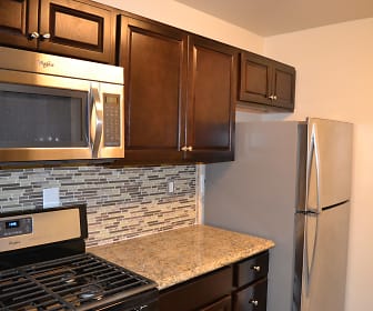 kitchen featuring stainless steel appliances, dark brown cabinets, and dark stone countertops, Willow Lake Apartment Homes
